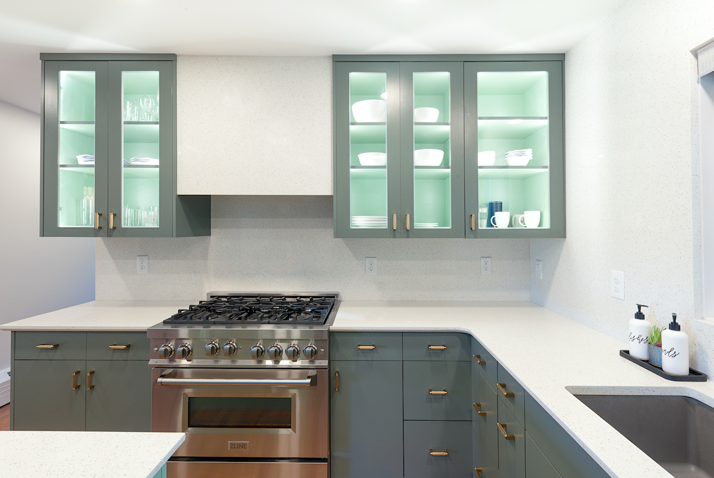 Sage green cabinets with backsplash to ceiling, white quartz
